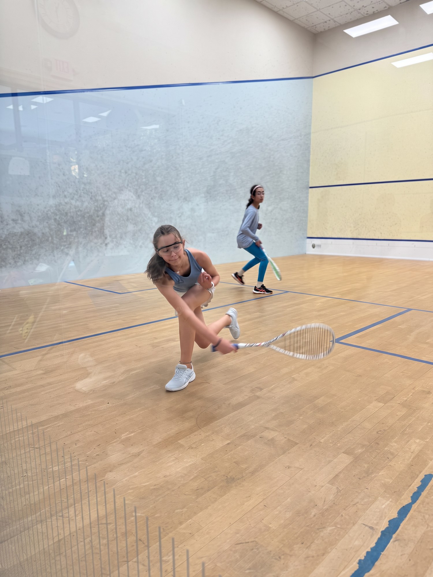 Two junior girls playing squash
